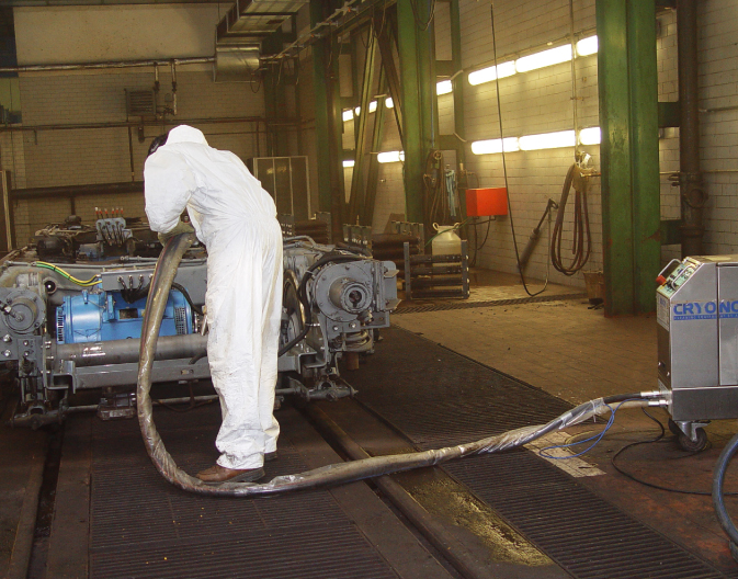 Man in white overalls and PPE performing Dry Ice contract cleaning on machinery