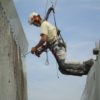 Someone on a harness dry ice blasting with COMBI72 to remove carbon