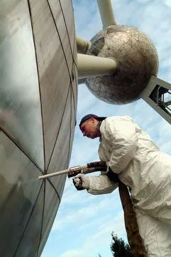 Person in a white suit dry ice blast cleaning a monument with COMBI73